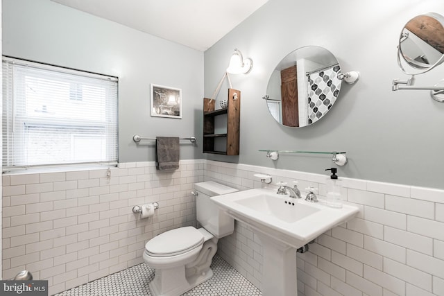 bathroom with tile walls, toilet, and tile patterned flooring