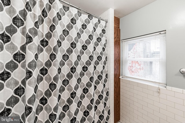 bathroom featuring tile walls and a shower with shower curtain