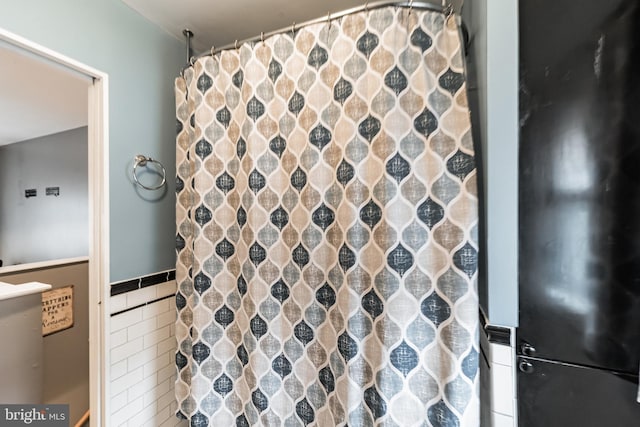 bathroom featuring tile walls and a shower with curtain