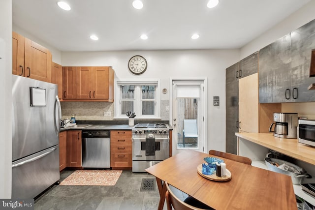 kitchen with backsplash, appliances with stainless steel finishes, and sink