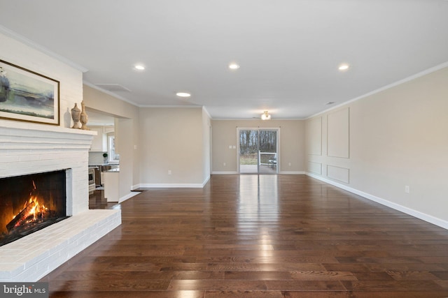 unfurnished living room with a brick fireplace, wood finished floors, and ornamental molding