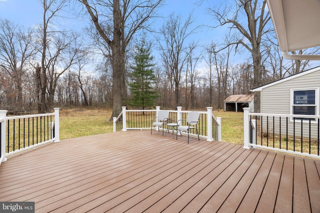 wooden deck featuring an outbuilding and a yard