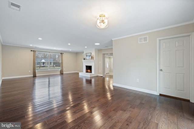 unfurnished living room with dark wood-style floors, visible vents, a lit fireplace, and baseboards