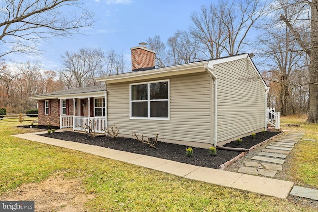 view of front of home featuring a front lawn, covered porch, and a chimney