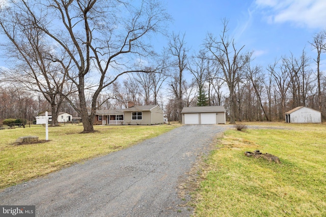 view of front of property featuring a garage, a chimney, an outdoor structure, and a front yard