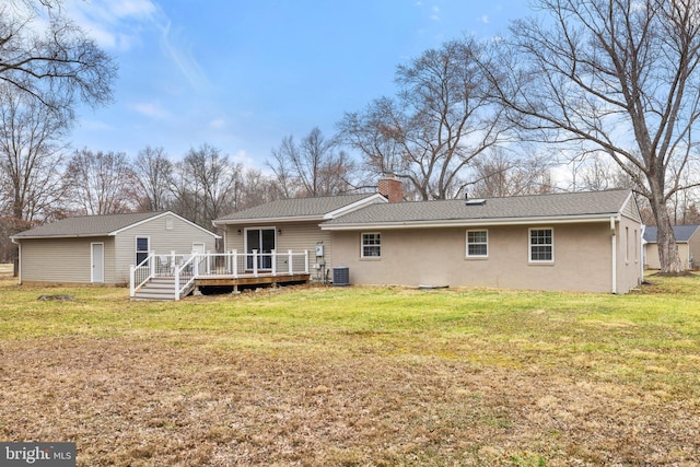 rear view of property with a wooden deck, central AC, stucco siding, a chimney, and a yard