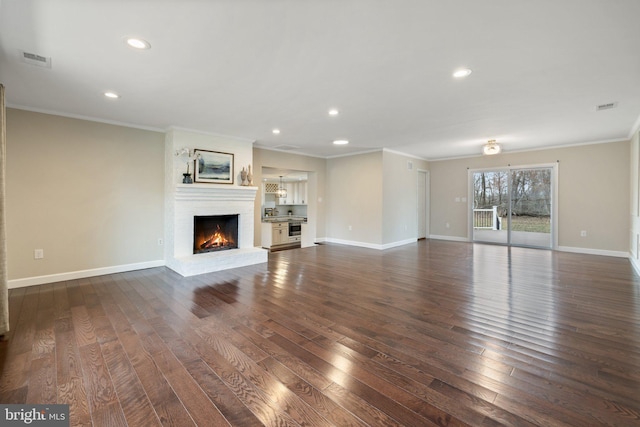 unfurnished living room featuring visible vents, dark wood-style floors, a fireplace, crown molding, and baseboards