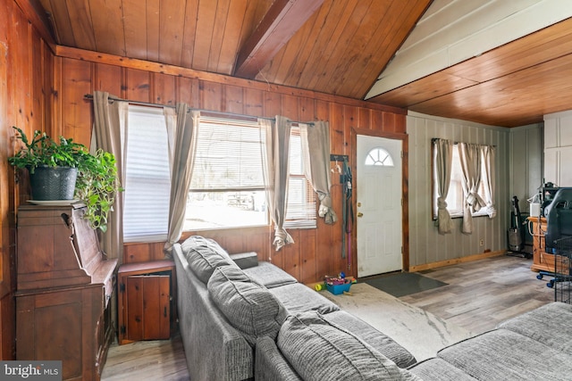 living room featuring lofted ceiling, wooden ceiling, wood walls, and light hardwood / wood-style flooring