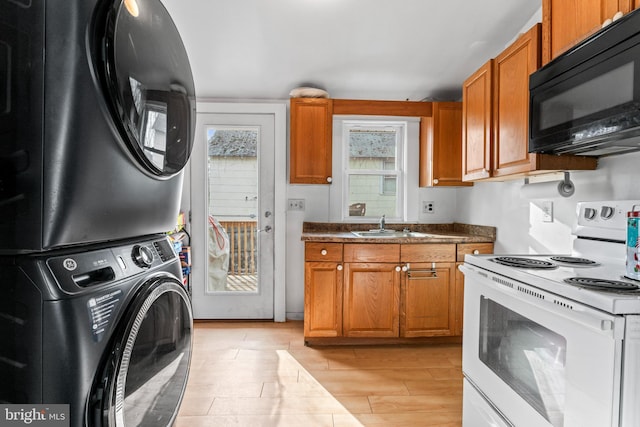 kitchen with sink, stacked washing maching and dryer, electric stove, and light hardwood / wood-style floors