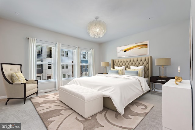 bedroom with light carpet and a chandelier