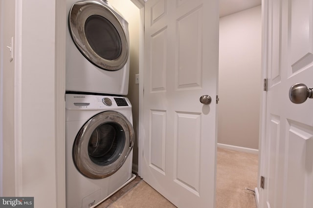 washroom with light tile patterned floors and stacked washer and dryer