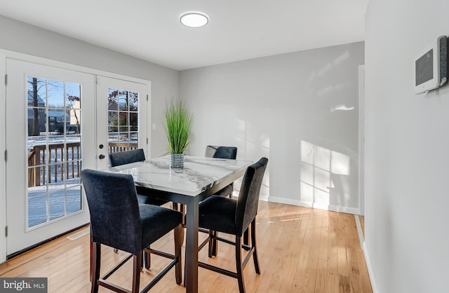 dining space featuring light wood-type flooring and french doors