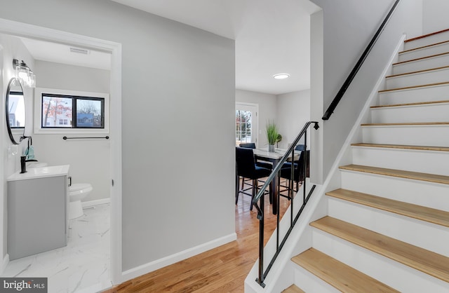 stairway with hardwood / wood-style flooring and sink