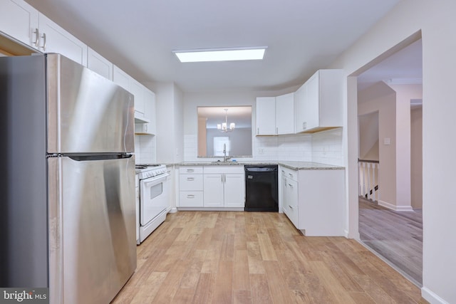 kitchen featuring white gas range oven, light hardwood / wood-style floors, stainless steel refrigerator, black dishwasher, and white cabinets