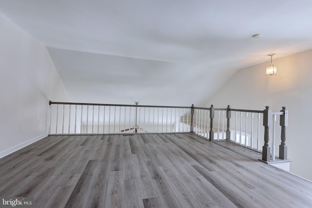 bonus room with hardwood / wood-style flooring and vaulted ceiling