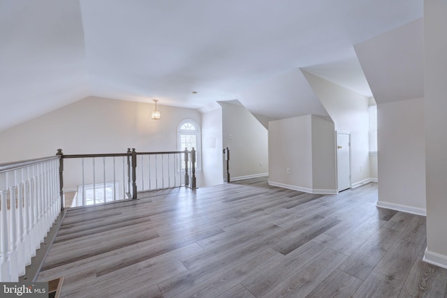 bonus room with lofted ceiling and light wood-type flooring