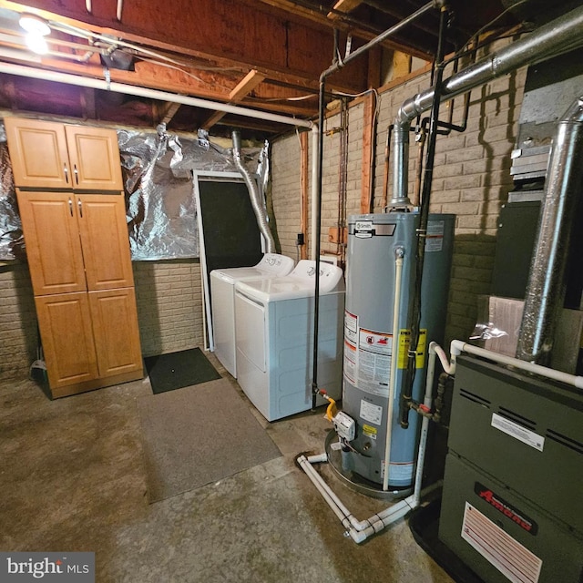 basement featuring brick wall, heating unit, washing machine and clothes dryer, and gas water heater