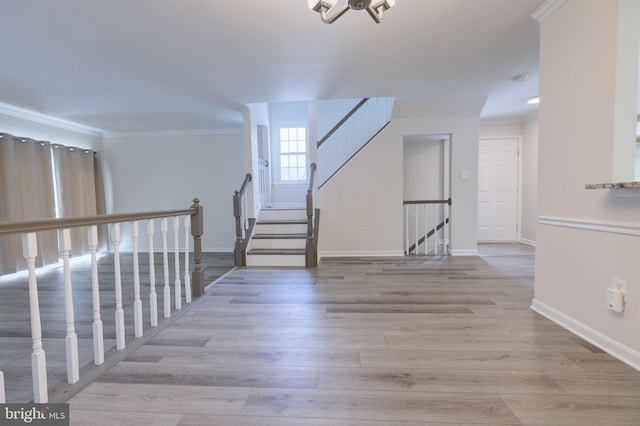 interior space with crown molding, a chandelier, and light hardwood / wood-style flooring