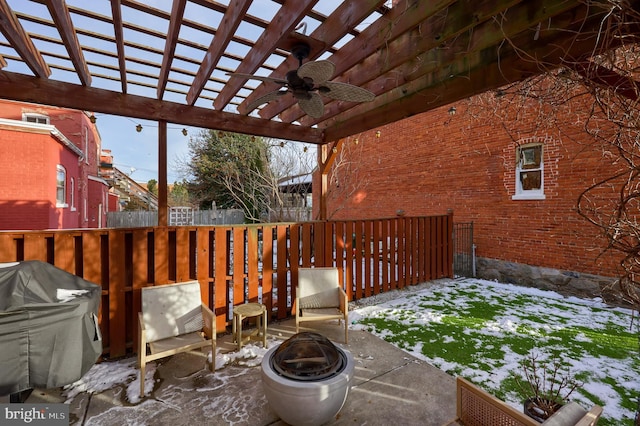 snow covered patio with a pergola, a fire pit, ceiling fan, and grilling area