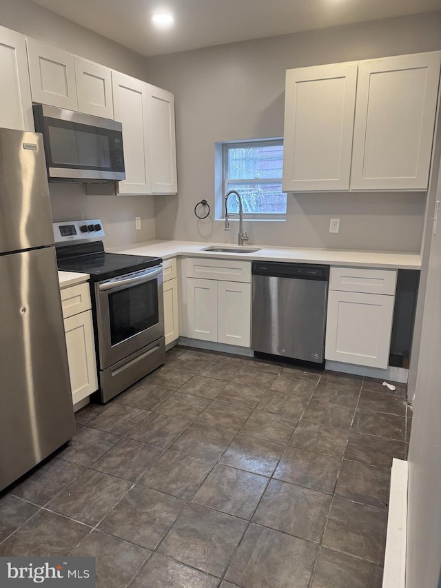 kitchen with white cabinets, appliances with stainless steel finishes, and sink