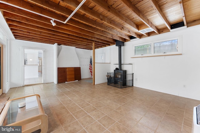 basement featuring wooden ceiling and a wood stove