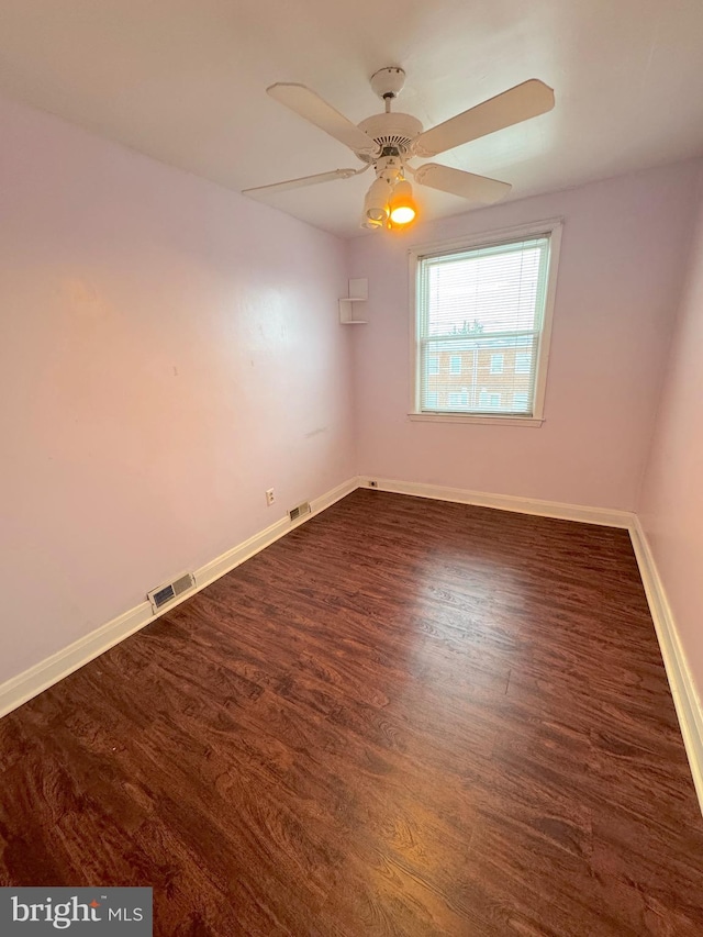 spare room with ceiling fan and dark hardwood / wood-style floors