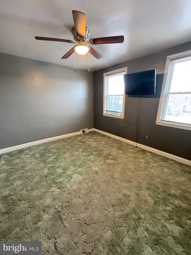 spare room with ceiling fan and carpet