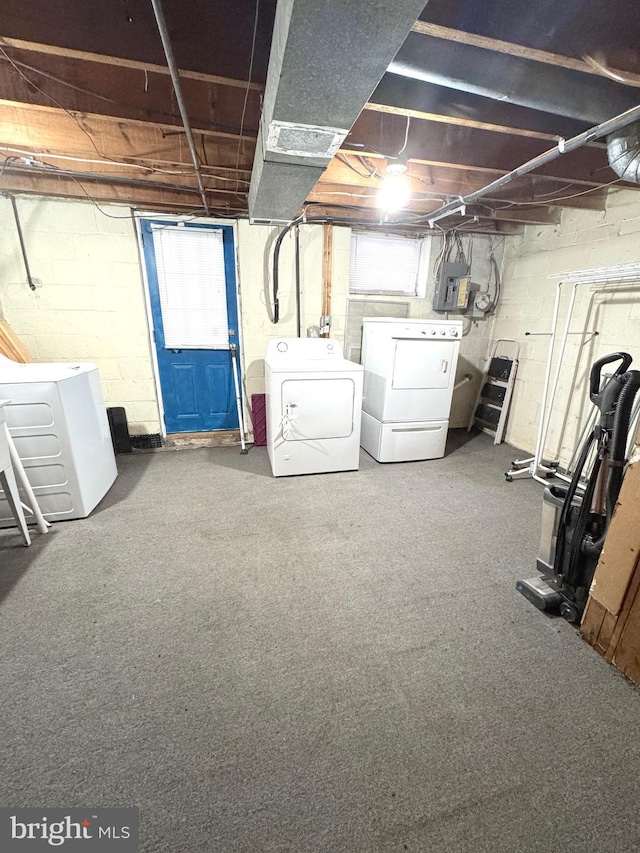 basement with washing machine and clothes dryer, electric panel, and carpet floors