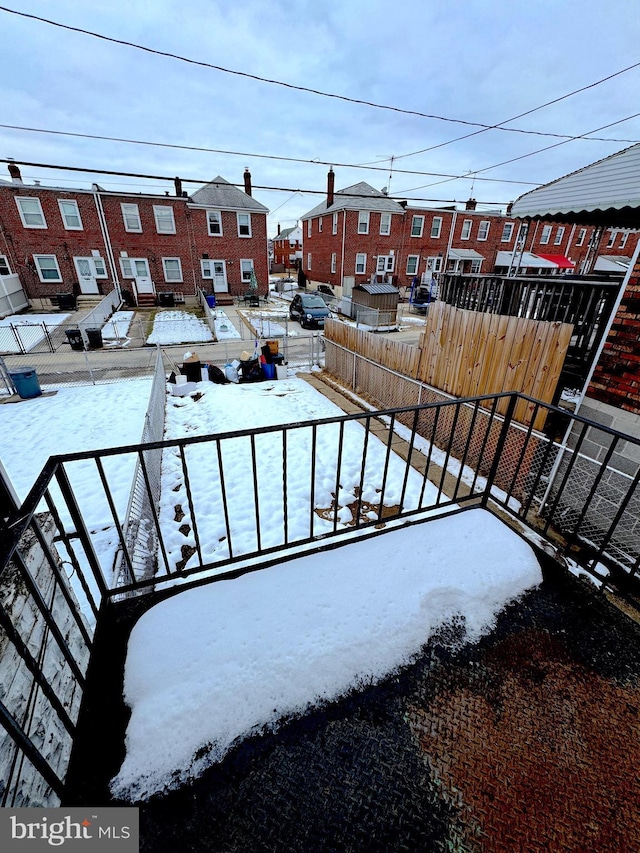 view of snow covered back of property