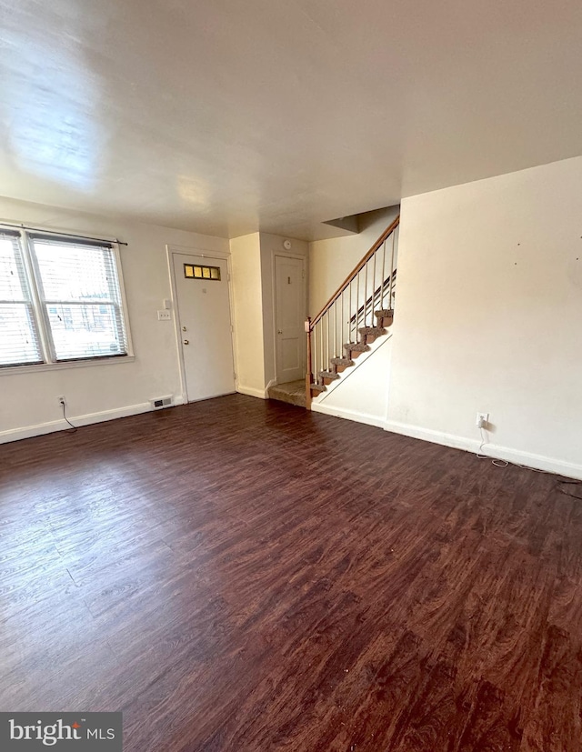 unfurnished living room featuring dark hardwood / wood-style floors