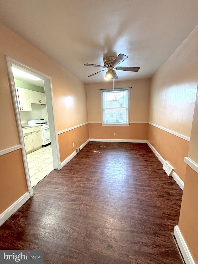 spare room with ceiling fan and dark hardwood / wood-style flooring