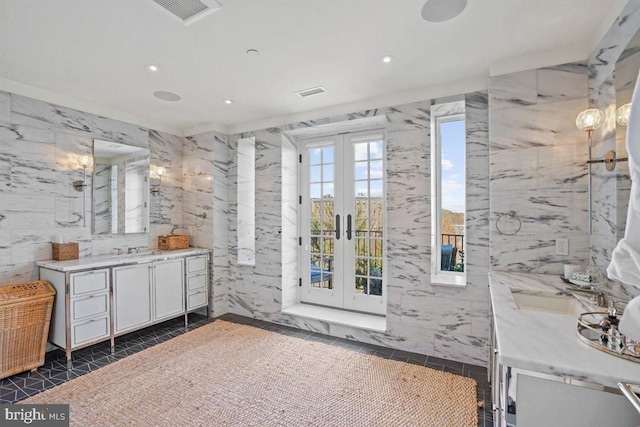 bathroom with tile walls, tile patterned flooring, french doors, and vanity