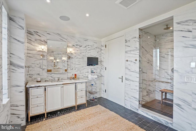 bathroom with tile walls, an enclosed shower, vanity, and tile patterned floors