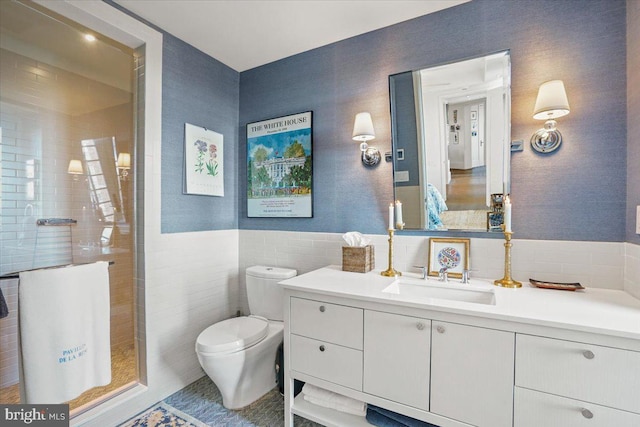 bathroom featuring tile walls, walk in shower, vanity, and toilet