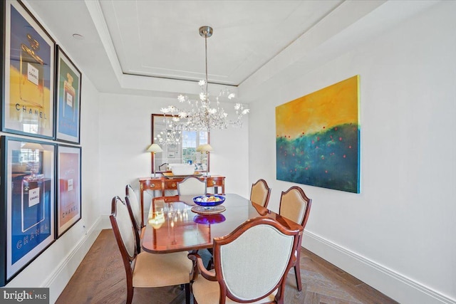 dining space with a notable chandelier, a tray ceiling, and dark hardwood / wood-style floors