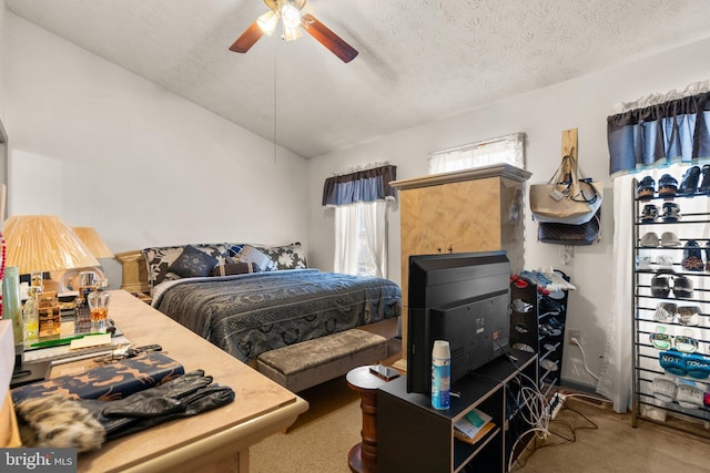 carpeted bedroom with ceiling fan, vaulted ceiling, and a textured ceiling