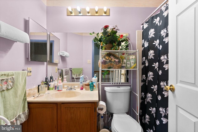 bathroom with walk in shower, vanity, and toilet