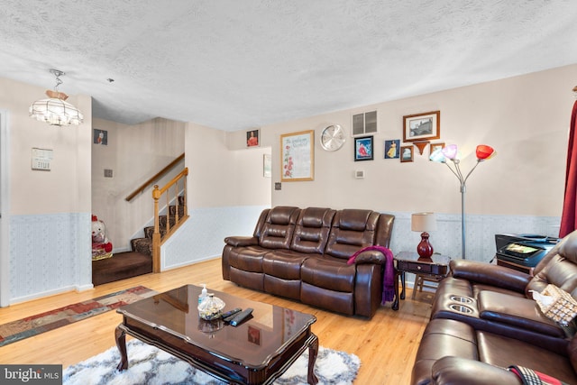 living room with a textured ceiling and light hardwood / wood-style flooring