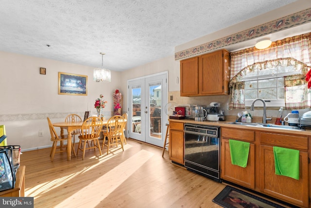 kitchen with french doors, sink, hanging light fixtures, dishwasher, and a healthy amount of sunlight