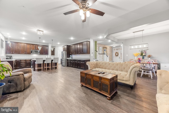 living room featuring ceiling fan and hardwood / wood-style floors