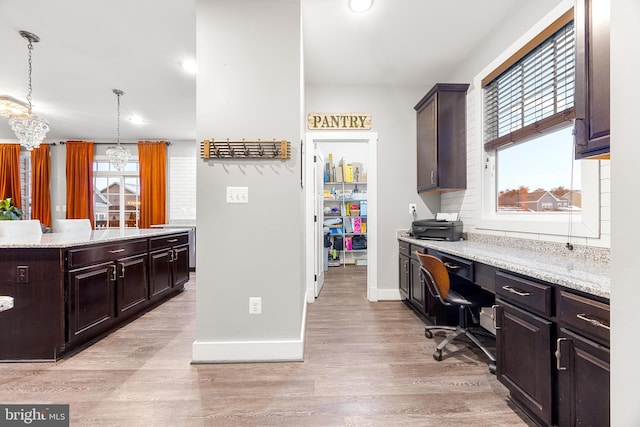 kitchen featuring decorative light fixtures, a wealth of natural light, and light wood-type flooring