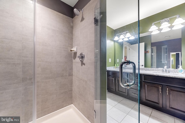 bathroom with tile patterned floors, tiled shower, and vanity