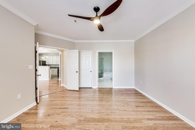 unfurnished room with ornamental molding, ceiling fan, and light wood-type flooring