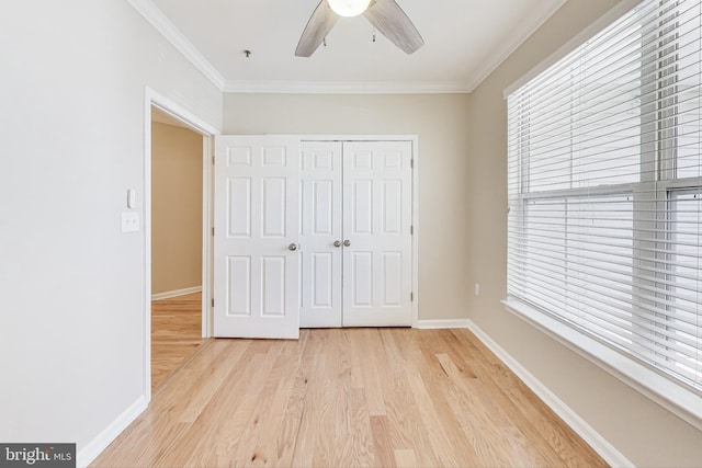 unfurnished bedroom with ceiling fan, light hardwood / wood-style flooring, a closet, and crown molding