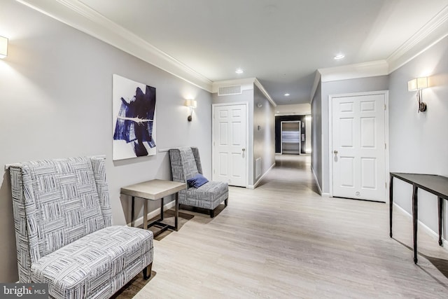 corridor featuring ornamental molding and light hardwood / wood-style flooring