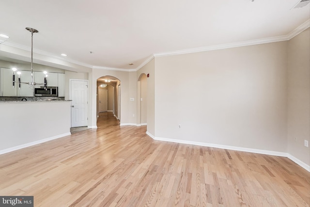 unfurnished living room featuring light wood-type flooring and crown molding