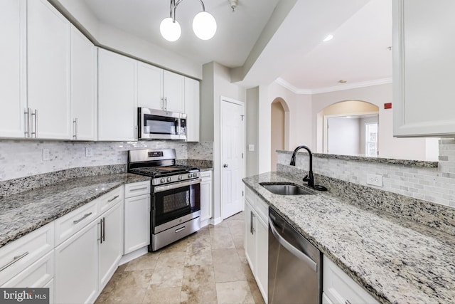 kitchen featuring sink, stainless steel appliances, white cabinetry, and light stone countertops