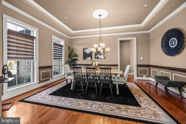 dining space with a raised ceiling and hardwood / wood-style flooring