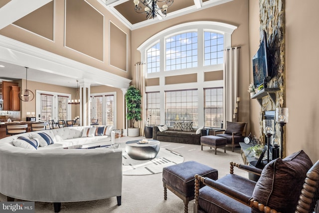 living area with a notable chandelier, carpet, and a healthy amount of sunlight