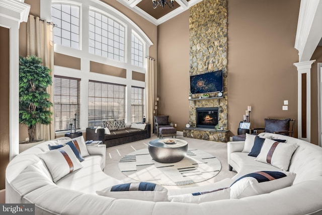 living room with beam ceiling, coffered ceiling, a high ceiling, a fireplace, and ornate columns